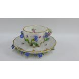 Meissen floral encrusted porcelain cup and saucer with blue cross sword marks, (2)