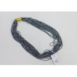 Multi strand necklace with yellow metal clasp, stamped 750