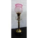 Young's brass oil lamp with clear glass well and cranberry coloured etched glass shade