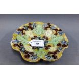 19th century French Palissy type dish with moulded heads and foliage pattern, 18cm diameter