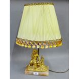 Faux giltwood cherub figural table lamp on a rectangular hardstone plinth, complete with shade