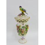 Continental porcelain vase and cover with a bird finial, reticulated top rim and floral encrusted