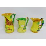 Three Burleigh ware yellow glazed jugs, one with a parrot handle and another with a Kingfisher