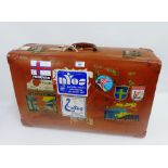 Vintage leather suitcase with remnants of travel labels and stickers