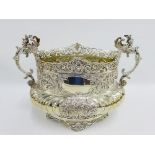 An impressive Victorian silver bowl with pierced top rim and repousee flowers and foliage, having