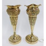 Pair of Eastern white metal vases, chased with village scene and flowers, with wavy rims and on