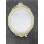 Carved and painted wooden mirror of oval form with ribbon and floral swag, 100 x 66cm