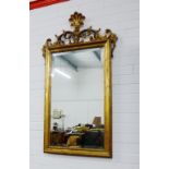 Giltwood wall mirror, the rectangular bevelled edge plate with shell and openwork surmount, 122 x