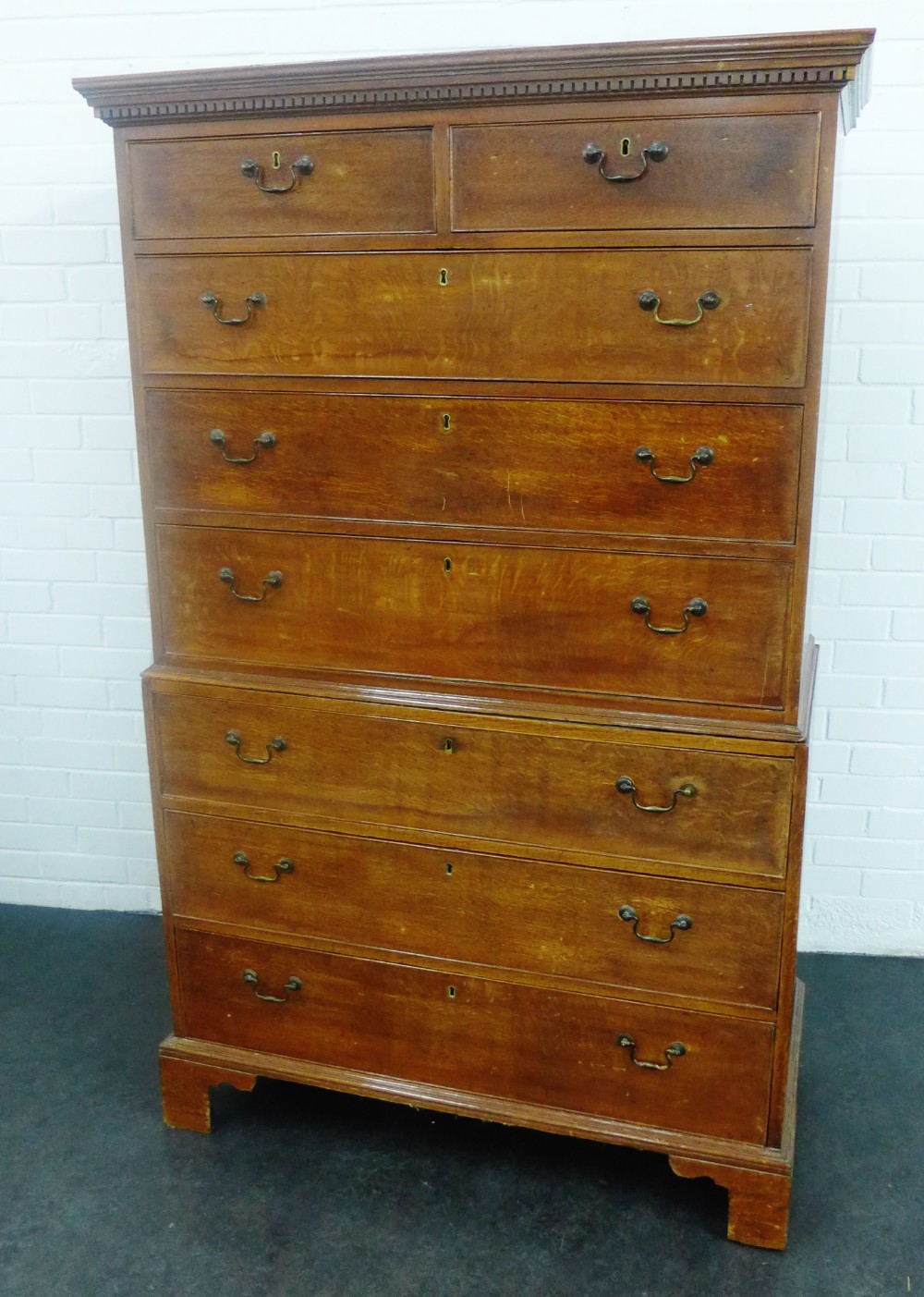 Oak chest on chest, the rectangular top with a dentil frieze over two short and six long drawers,