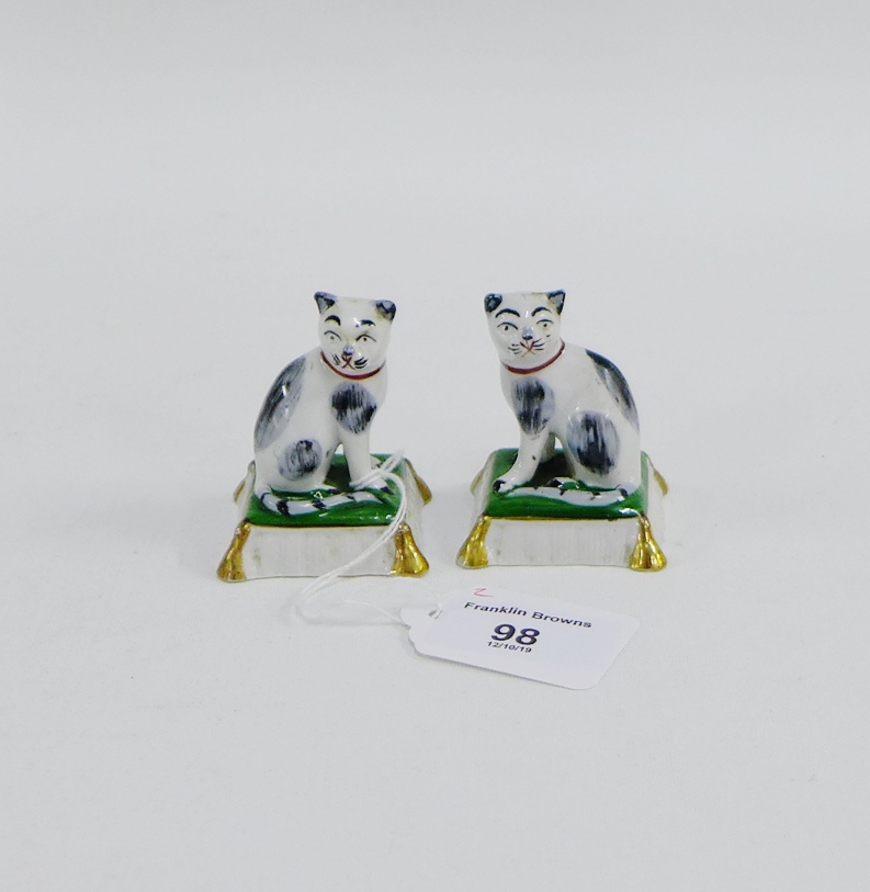 Pair of porcelain black and white cats on cushion bases, 6cm high, (2)