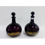 Pair of 19th century aubergine coloured glass Pharmacy bottles and stoppers with gilt labels, 38cm