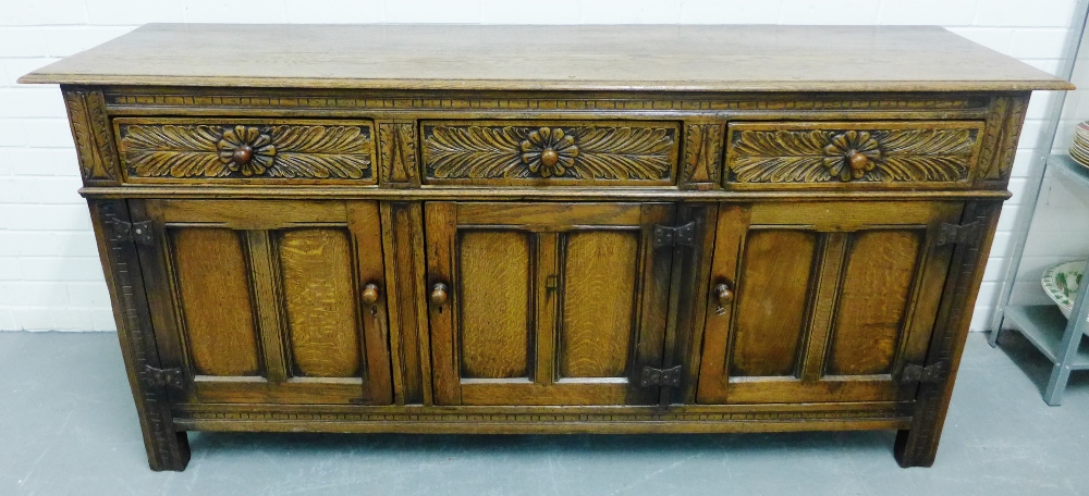 Oak sideboard, the rectangular top over with three carved frieze drawers and panelled cupboard three