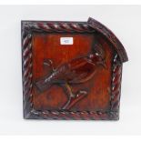 A carved wooden panel depicting a bird with spiral borders, 33 x 33cm