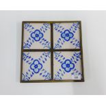 Four Delft blue and white tiles contained within a single pewter frame, size overall 27 x 27cm