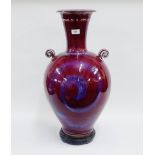 Large Sang de Boeuf style vase with loop handles to side and a turned wooden base, height overall,