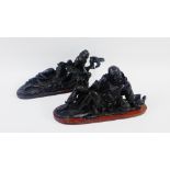 Pair of ebonised carved chinoiserie figures on wooden bases, 32cm long, (2)