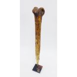 Iatmul, Papa New Guinea Cassowary dagger with carved decoration and serrated edge, on a wooden stand