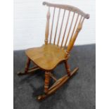 Rocking chair with foliate carved toprail, spindle back and solid seat, (a/f), 84 X 44cm