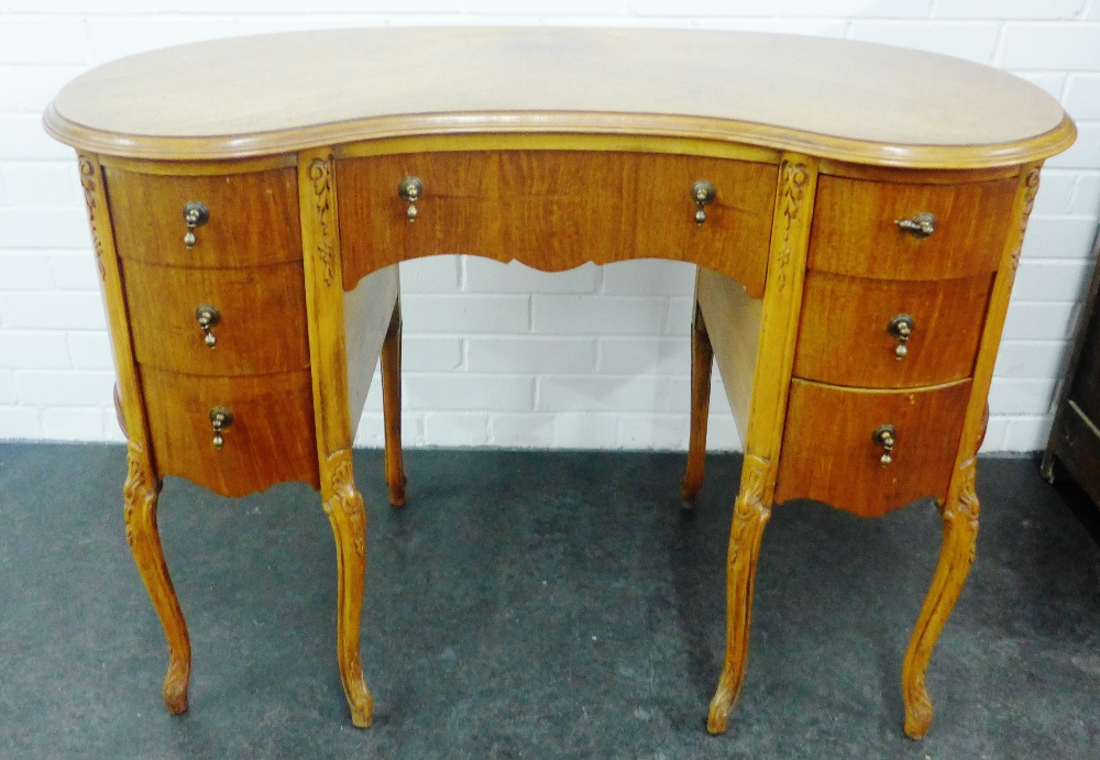 Walnut veneered kidney shaped dressing table with three drawers to each pedestal and central long
