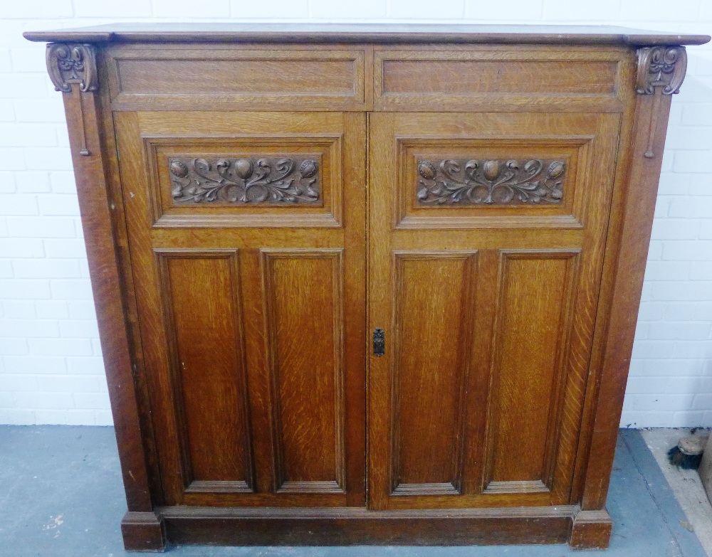 Arts & Crafts oak cupboard, the doors with carved foliate panels, 144 x 148cm