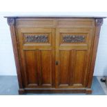 Arts & Crafts oak cupboard, the doors with carved foliate panels, 144 x 148cm