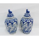 Pair of Delft blue and white octagonal baluster vases and covers painted with birds, flowers,