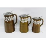 Graduated set of three Paxton stoneware jugs, the brown ground with white ivy leaf pattern and