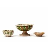 A GOOD GROUP OF THREE SANCAI VESSELS, TANG DYNASTYThe stem cup with a flamboyant glaze in superb