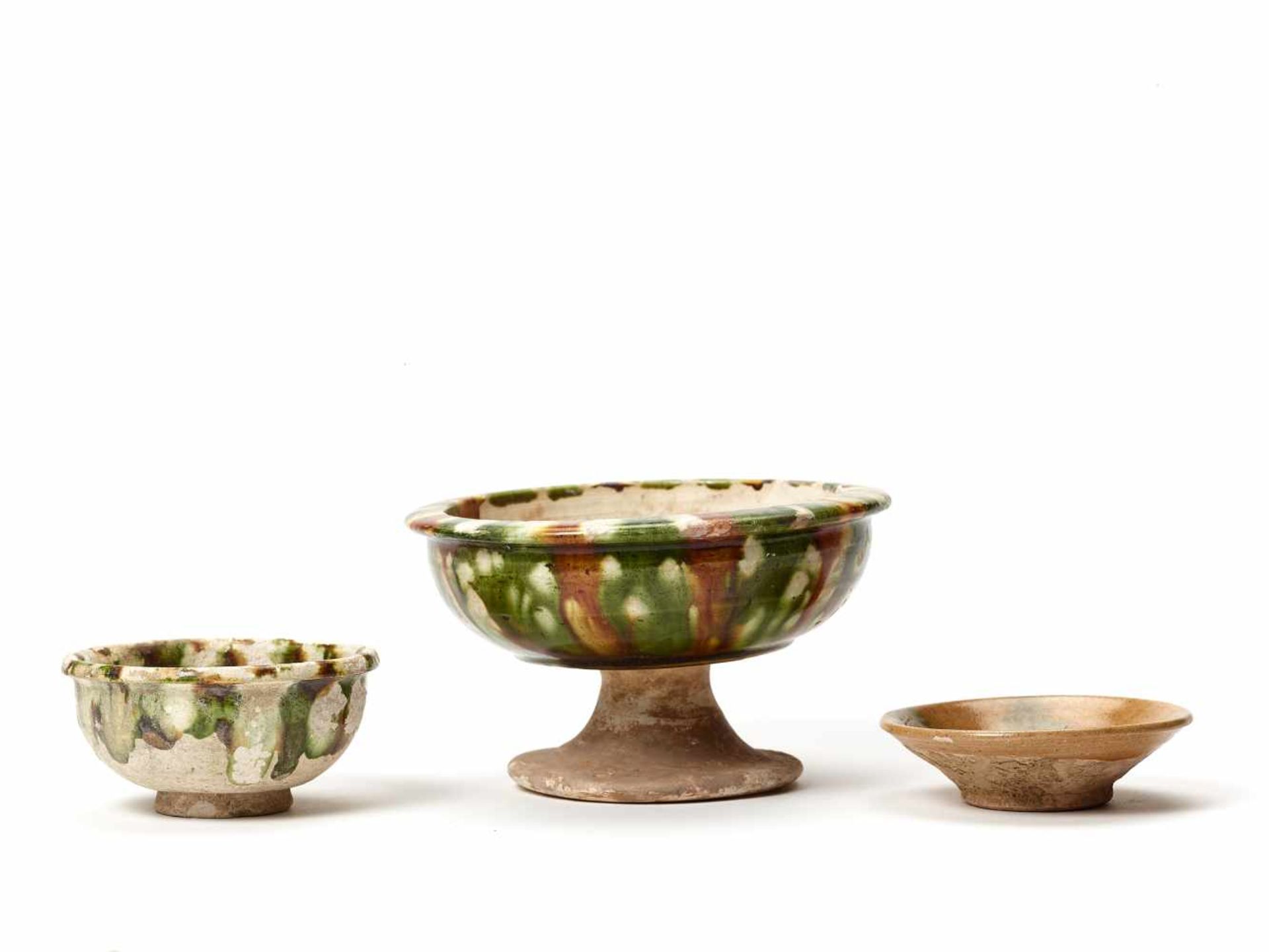 A GOOD GROUP OF THREE SANCAI VESSELS, TANG DYNASTYThe stem cup with a flamboyant glaze in superb