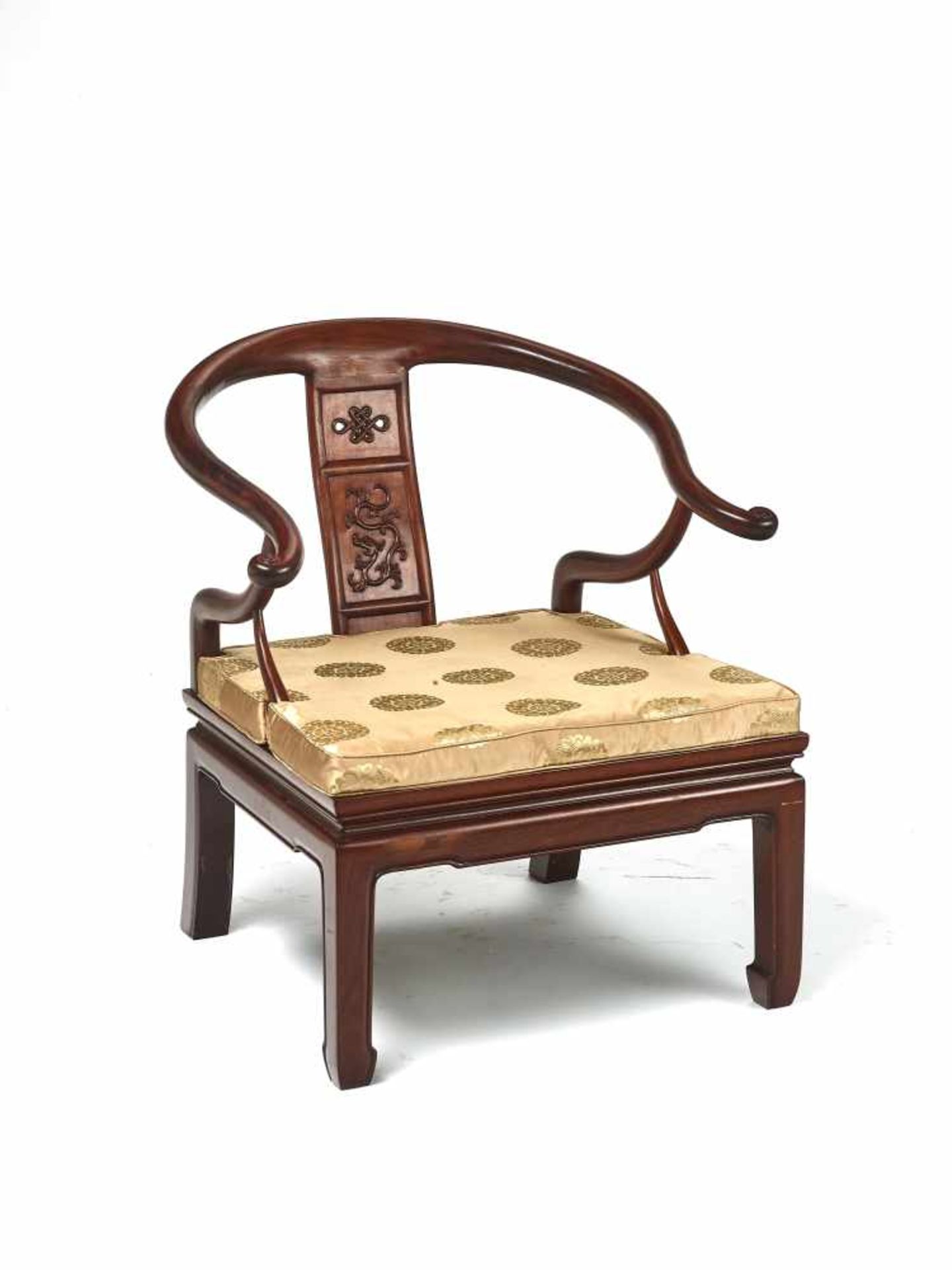 A CHINESE ‘HORSESHOE’ LOW CHAIR, LATE QING DYNASTYCarved from hardwood, possibly Huanghuali, with