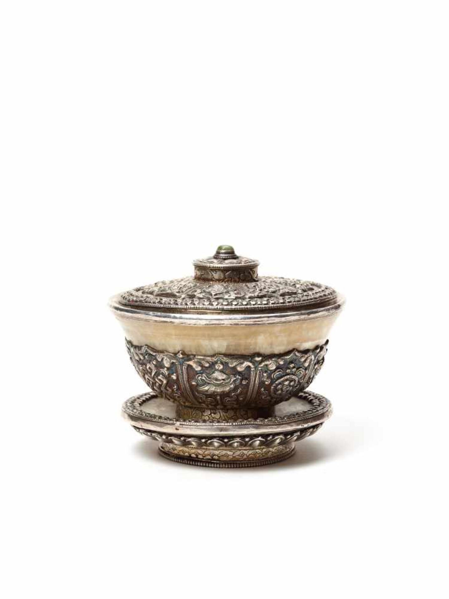 A FINE TIBETAN BUDDHIST SILVER TEA BOWL, 19TH CENTURYThe marble vessel retaining its matching lid