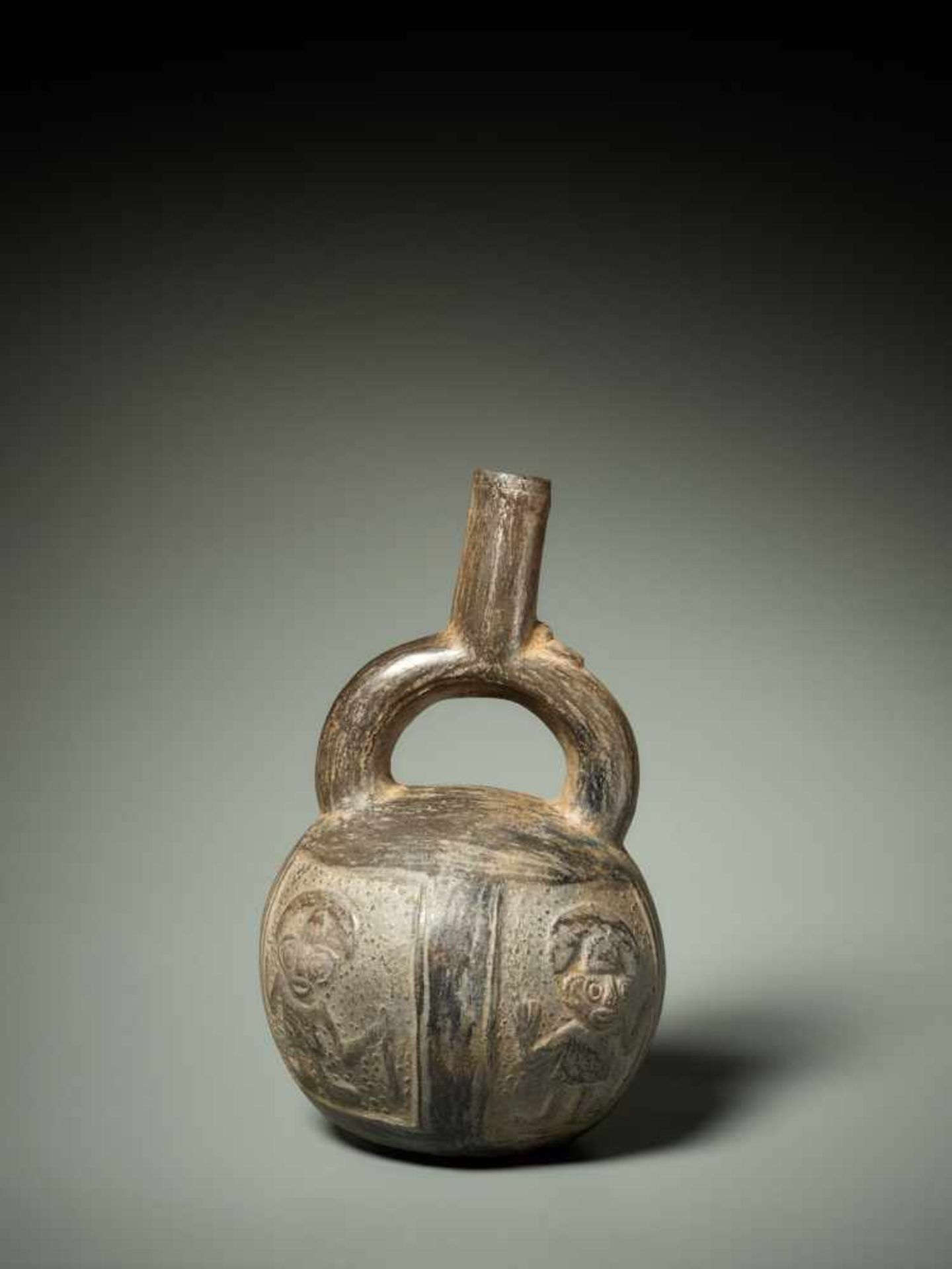 STIRRUP VESSEL WITH RELIEF DECORATION – CHIMU CULTURE, PERU, C. 1000-1400 ADBlack fired clayChimu