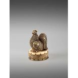 A FINE NETSUKE OF A COCKEREL ON A DRUM BY KOJITSU By Kojitsu, ivory netsuke with horn inlayJapan,