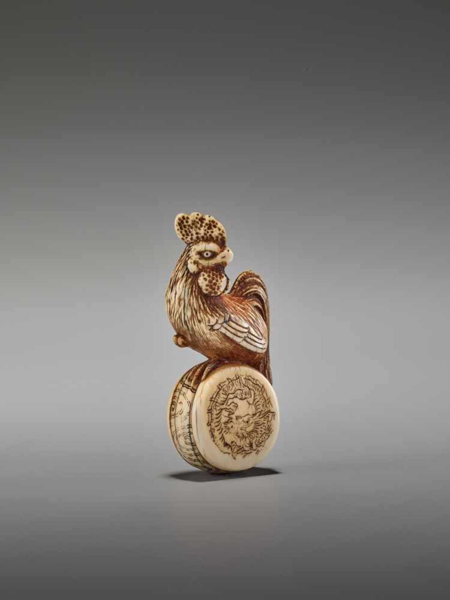 A GOOD KYOTO SCHOOL IVORY NETSUKE OF A COCKEREL ON A WAR DRUMUnsigned, ivory netsukeJapan, Kyoto,