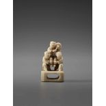 AN IVORY NETSUKE OF THREE CHINESE BOYS AND A DRUMUnsigned, ivory netsukeJapan, late 18th to early