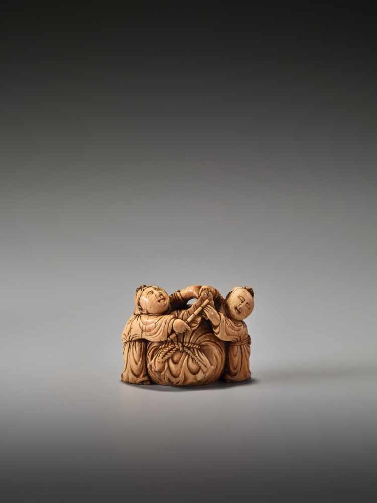 A VERY RARE 17TH CENTURY IVORY NETSUKE OF TWO CHINESE BOYS WITH HOTEI’S SACKUnsigned, ivory