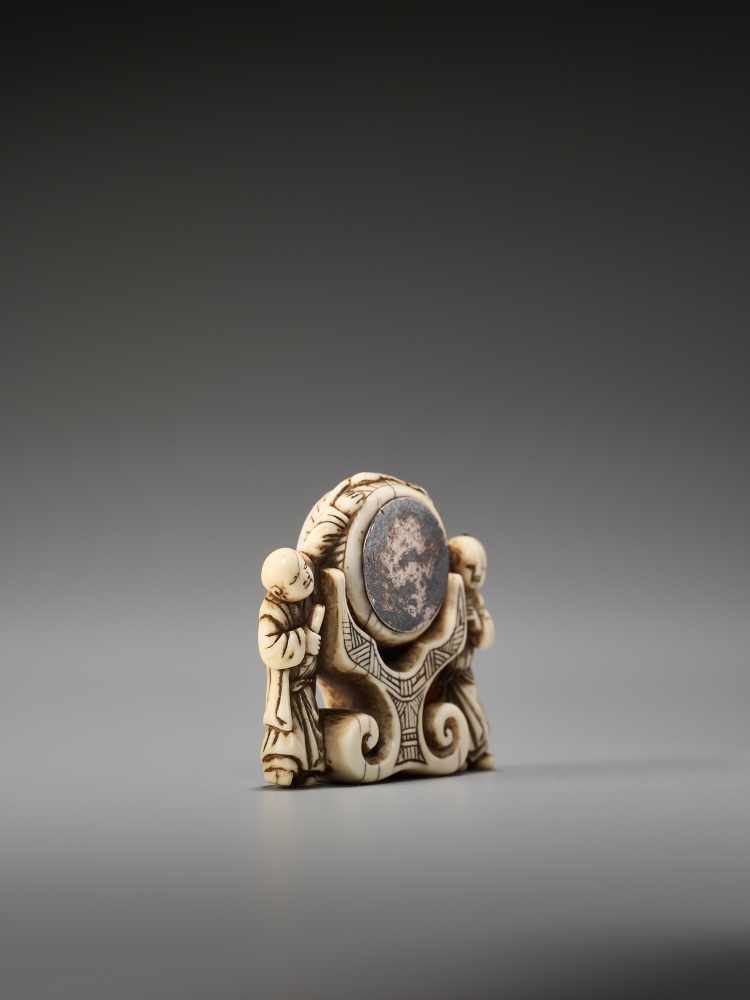 A RARE AND UNUSUAL IVORY NETSUKE OF TWO CHINESE BOYS AT A PALACE GONGUnsigned, ivory netsuke with - Image 5 of 6