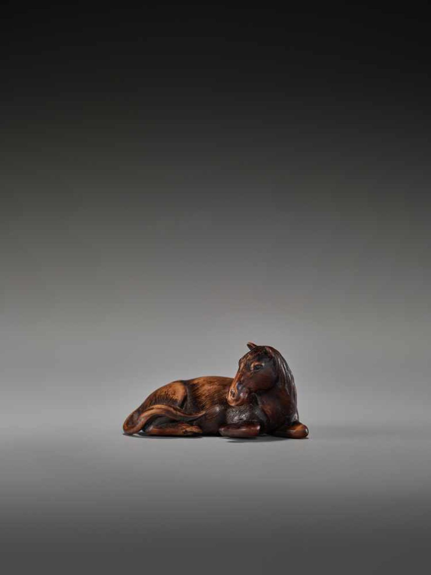 A FINE WOOD NETSUKE OF A RECUMBENT HORSEUnsigned, wood netsukeJapan, 19th century, Edo period (