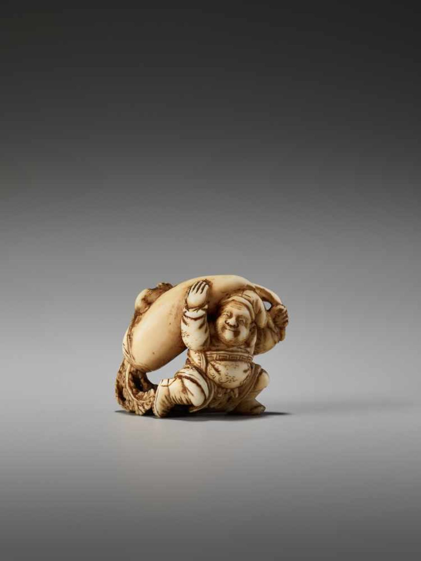 A SMALL IVORY NETSUKE OF DAIKOKU WITH DAIKON AND RAT BY THE TOMOCHIKA SCHOOLBy Tomochika, ivory