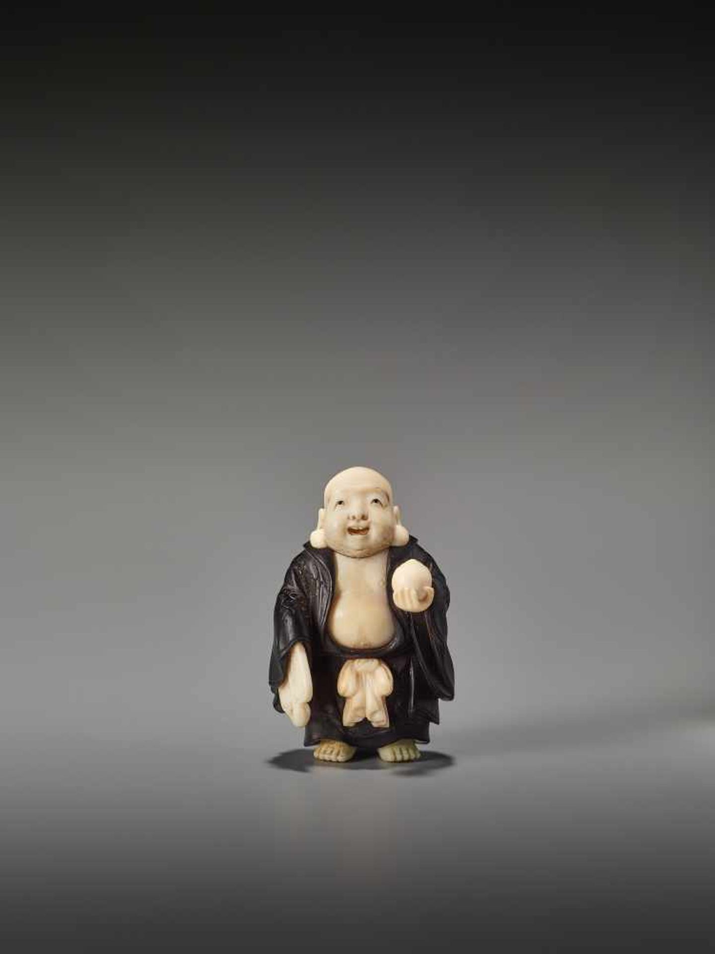 A FINE TOKYO SCHOOL EBONY AND IVORY NETSUKE OF HOTEI BY TOYOSAIBy Toyosai, ebony wood and ivory