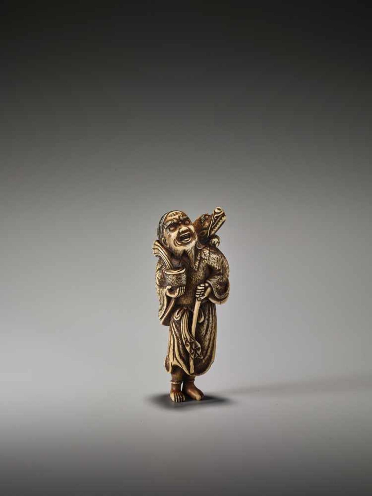 A POWERFUL TALL IVORY NETSUKE OF CHINNAN SENNIN WITH DRAGON AND TAMING STICKUnsigned, ivory