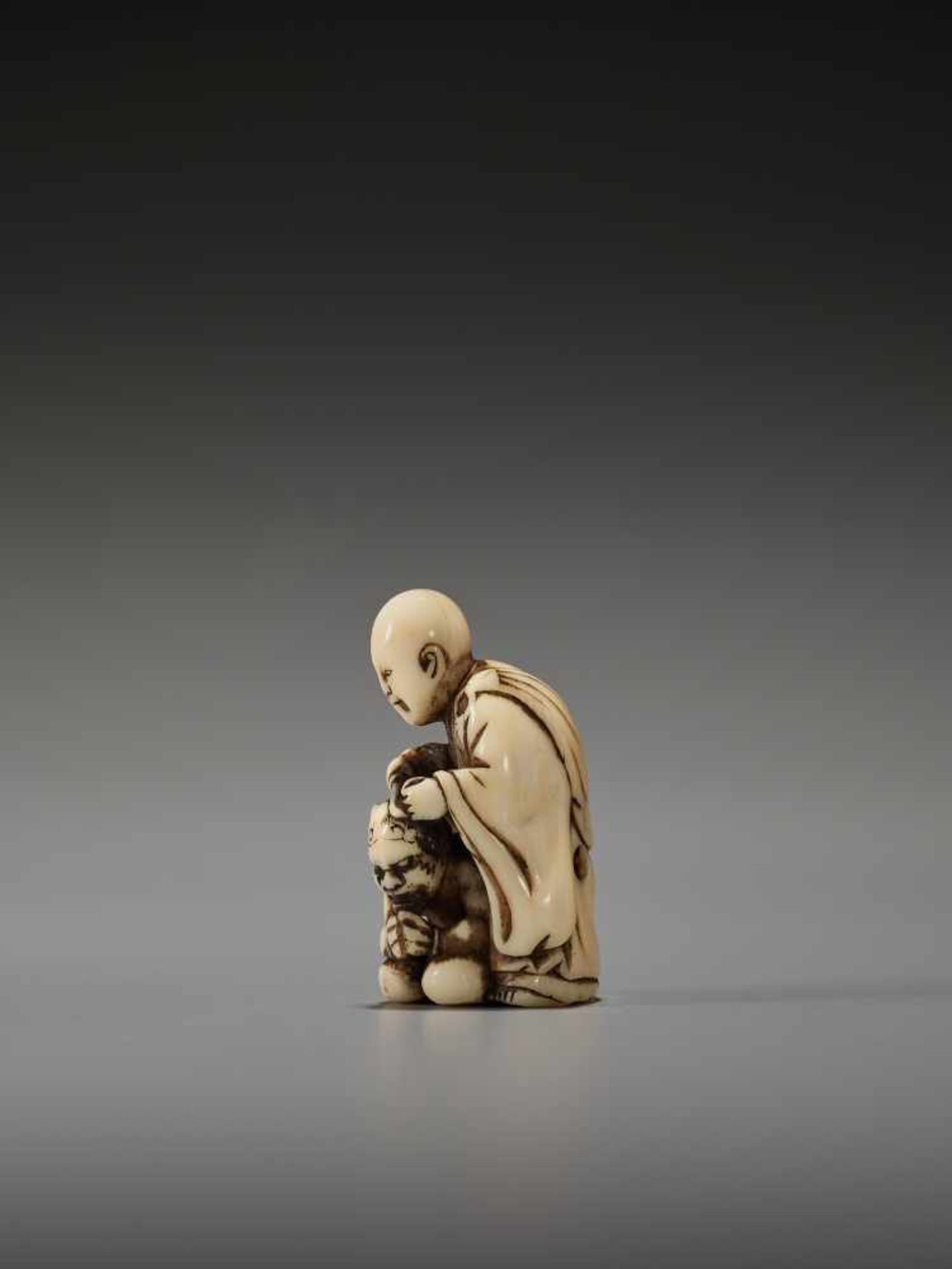 AN IVORY NETSUKE OF A MONK AND REPENTANT ONIUnsigned, Tomochika school, ivory netsukeJapan, mid to - Image 3 of 7