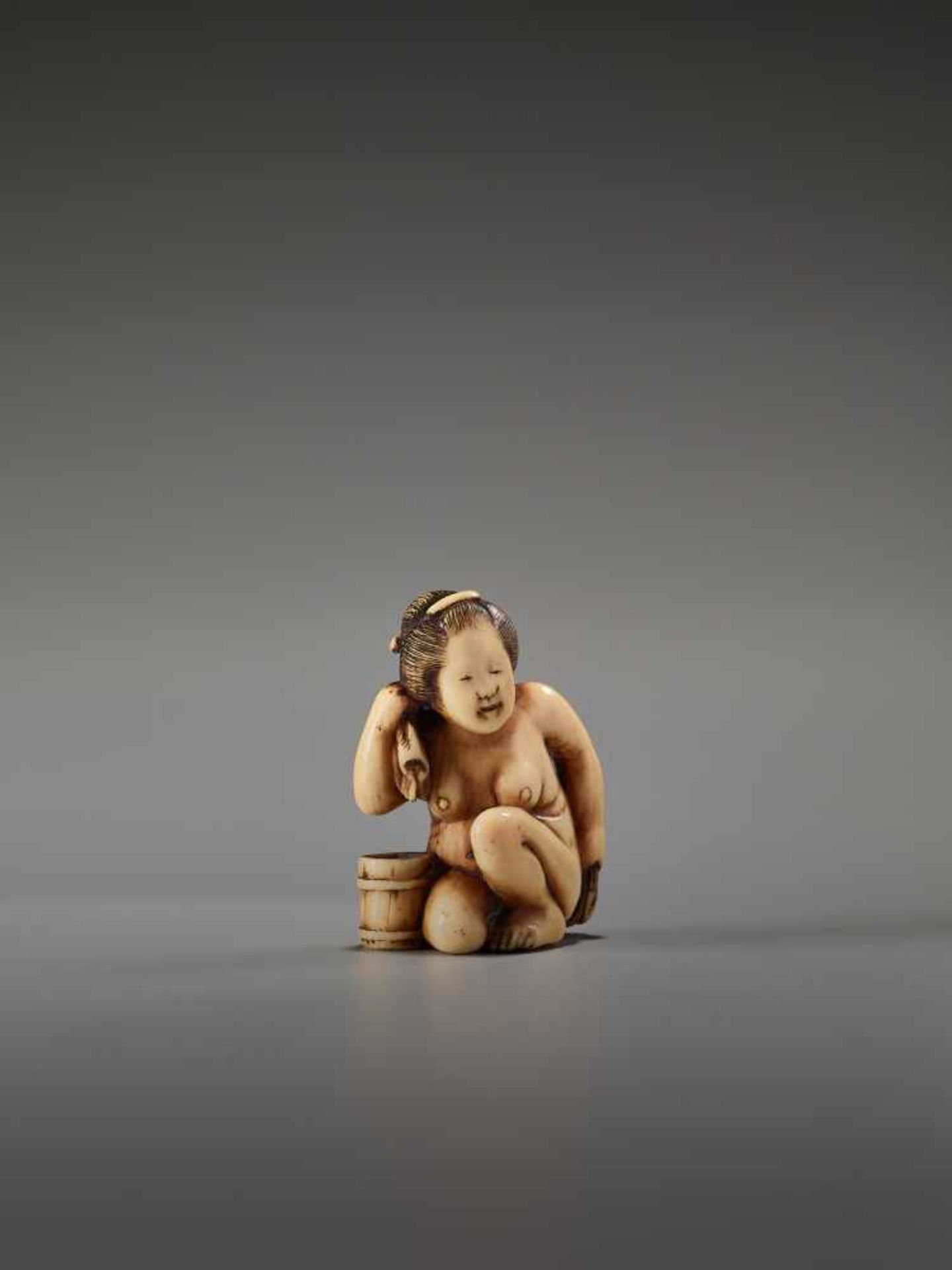 AN IVORY SHUNGA NETSUKE OF A NUDE WOMAN WASHING HERSELF BY THE TOMOCHIKA SCHOOLBy Tomochika, ivory - Image 2 of 7