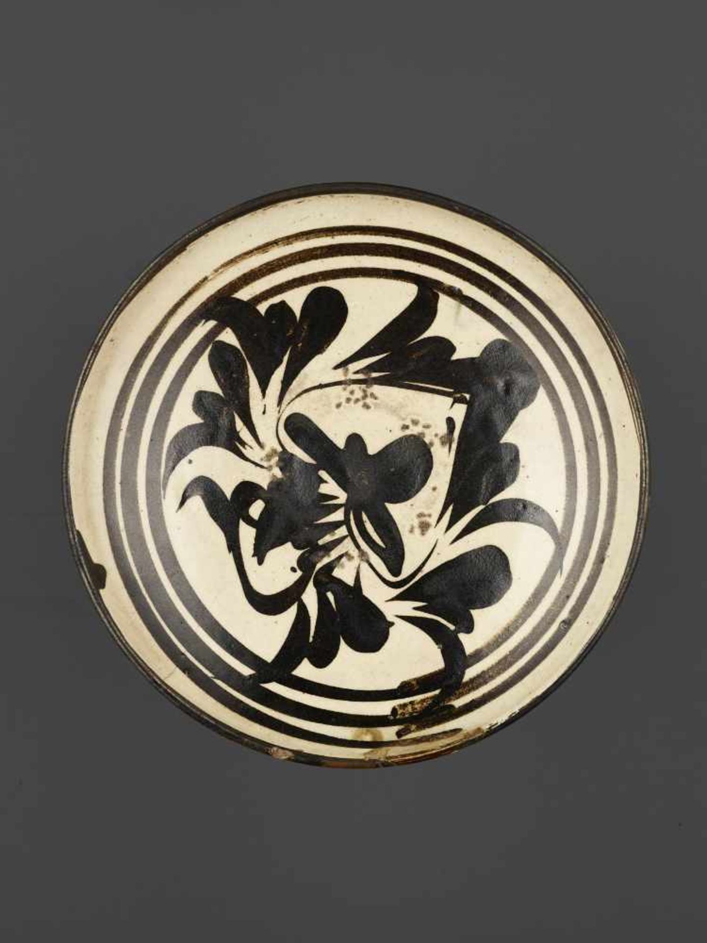 A PAINTED CIZHOU BOWL, SONG DYNASTYChina, Song dynasty (960-1279). The creamy-white glaze painted in