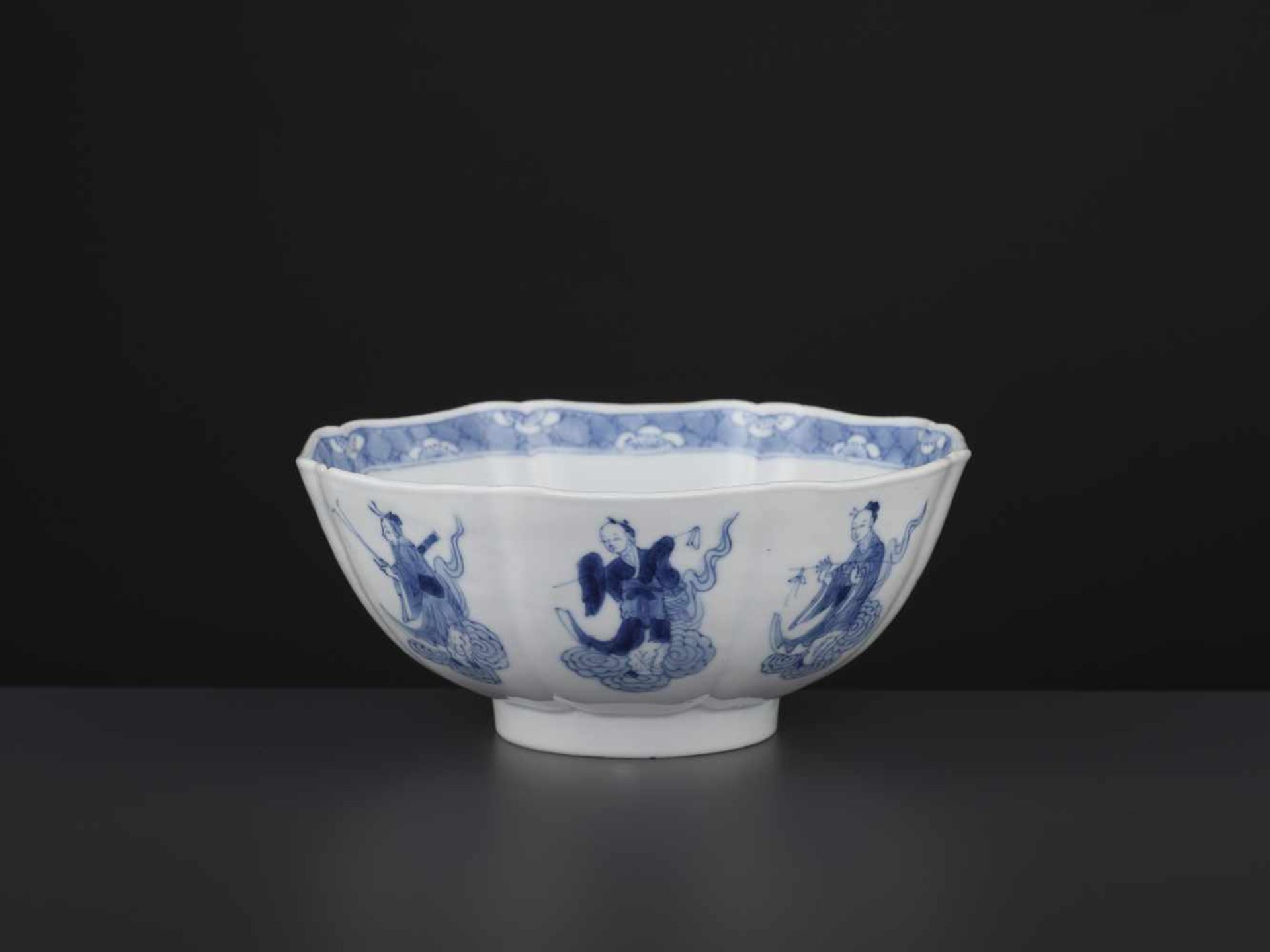 A KANGXI IMMORTALS BOWLChina, 1662-1722. The eight-lobed vessel neatly painted in cobalt blue