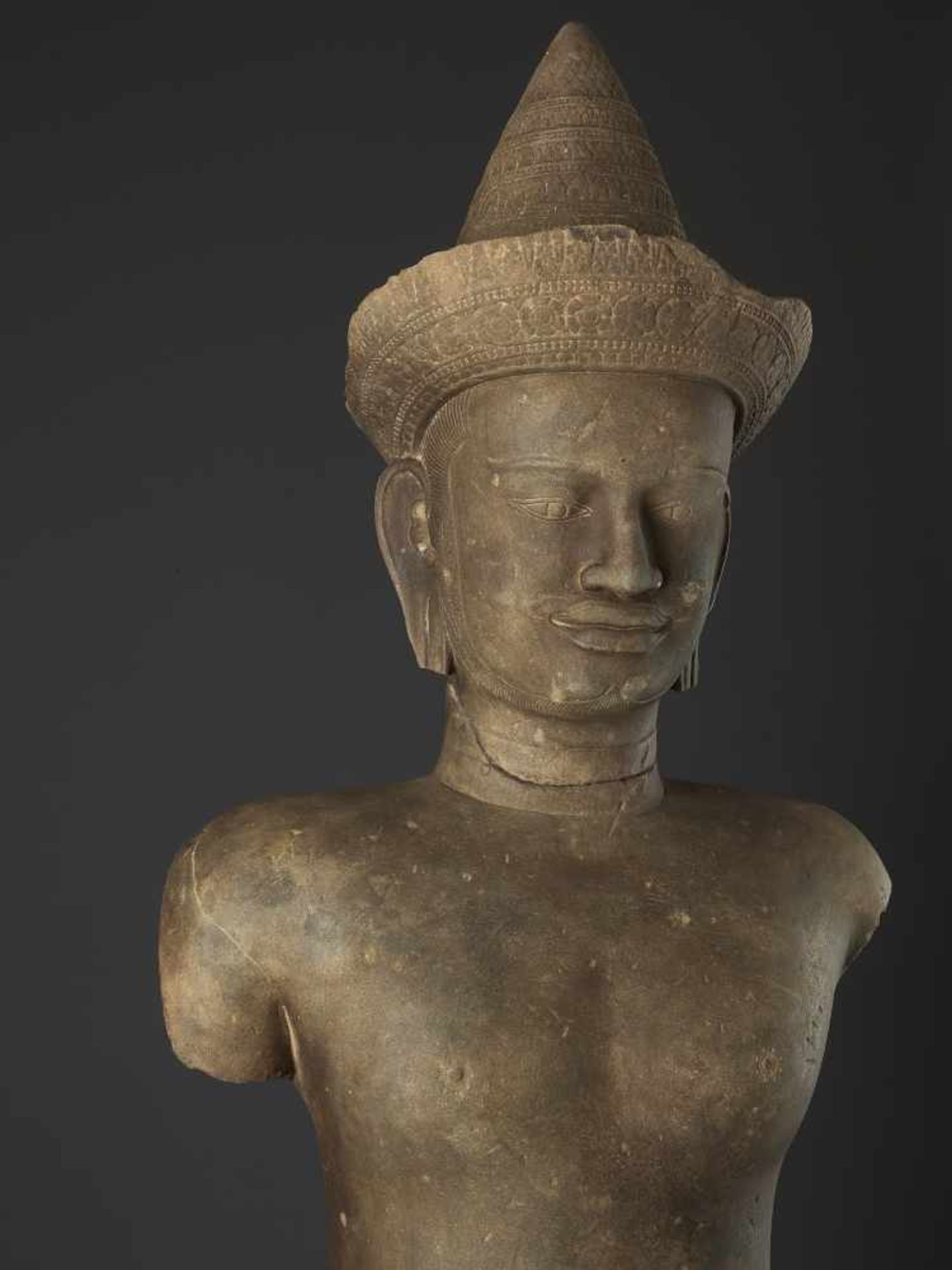 A LARGE KHMER STATUE OF VISHNU11th - 12th century. Carved sandstone. Vishnu stands in samabhanga