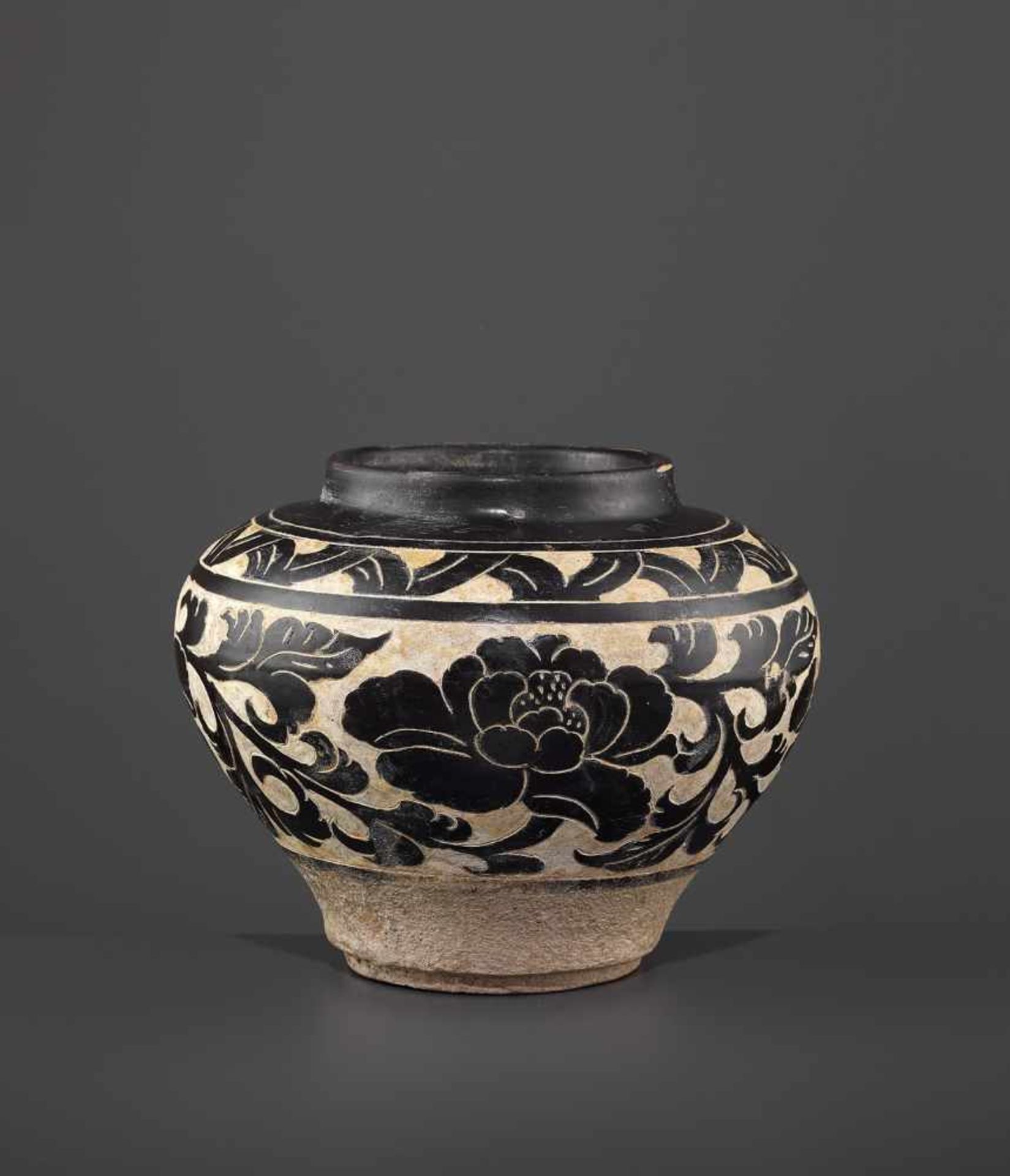 A SMALL CARVED CIZHOU JAR, JIN China, Jin dynasty (1115-1234). Freely carved through the brown