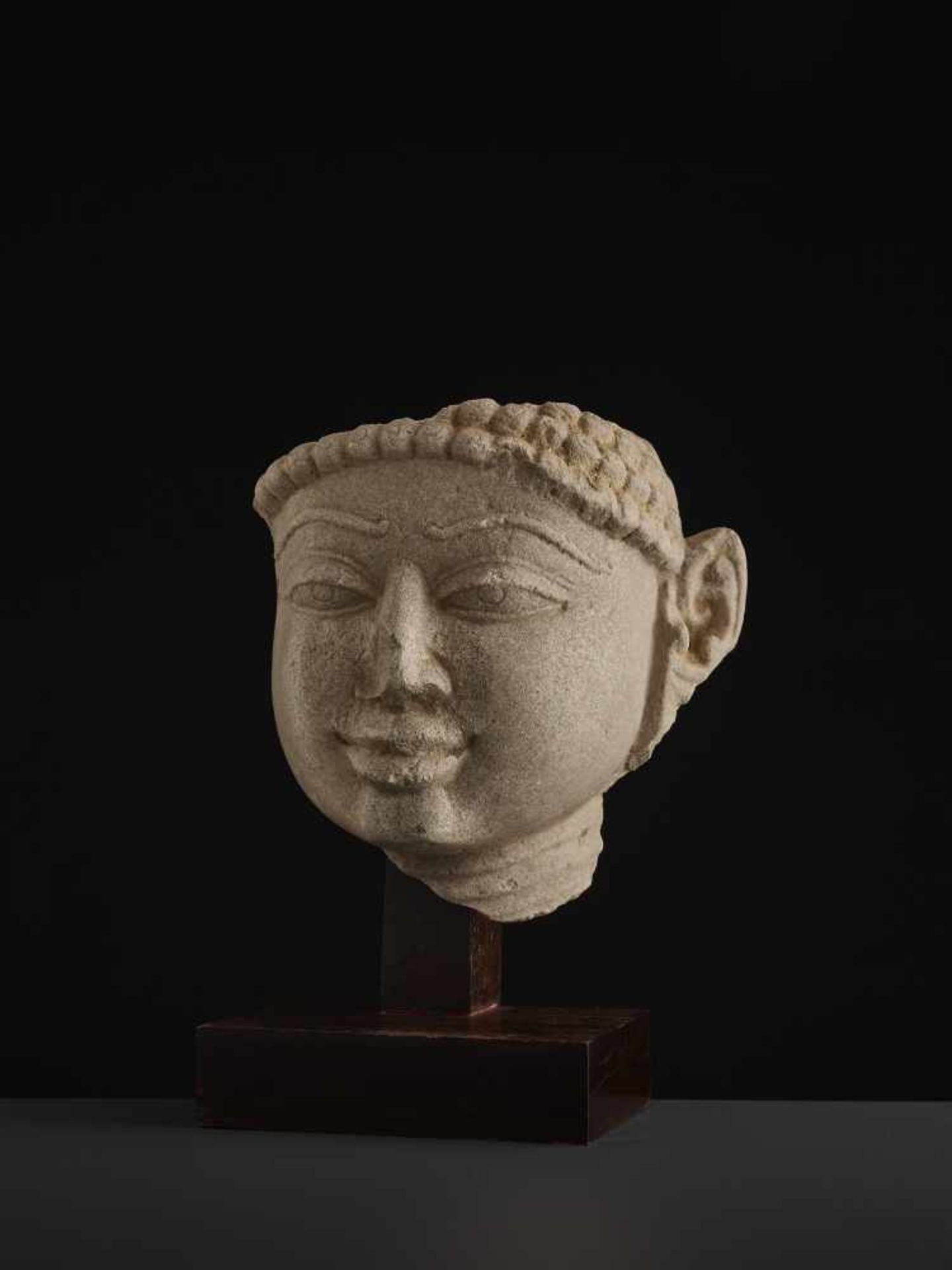 A SANDSTONE HEAD OF A TIRTHANKARACentral India, 11th - 13th century. A large and finely carved