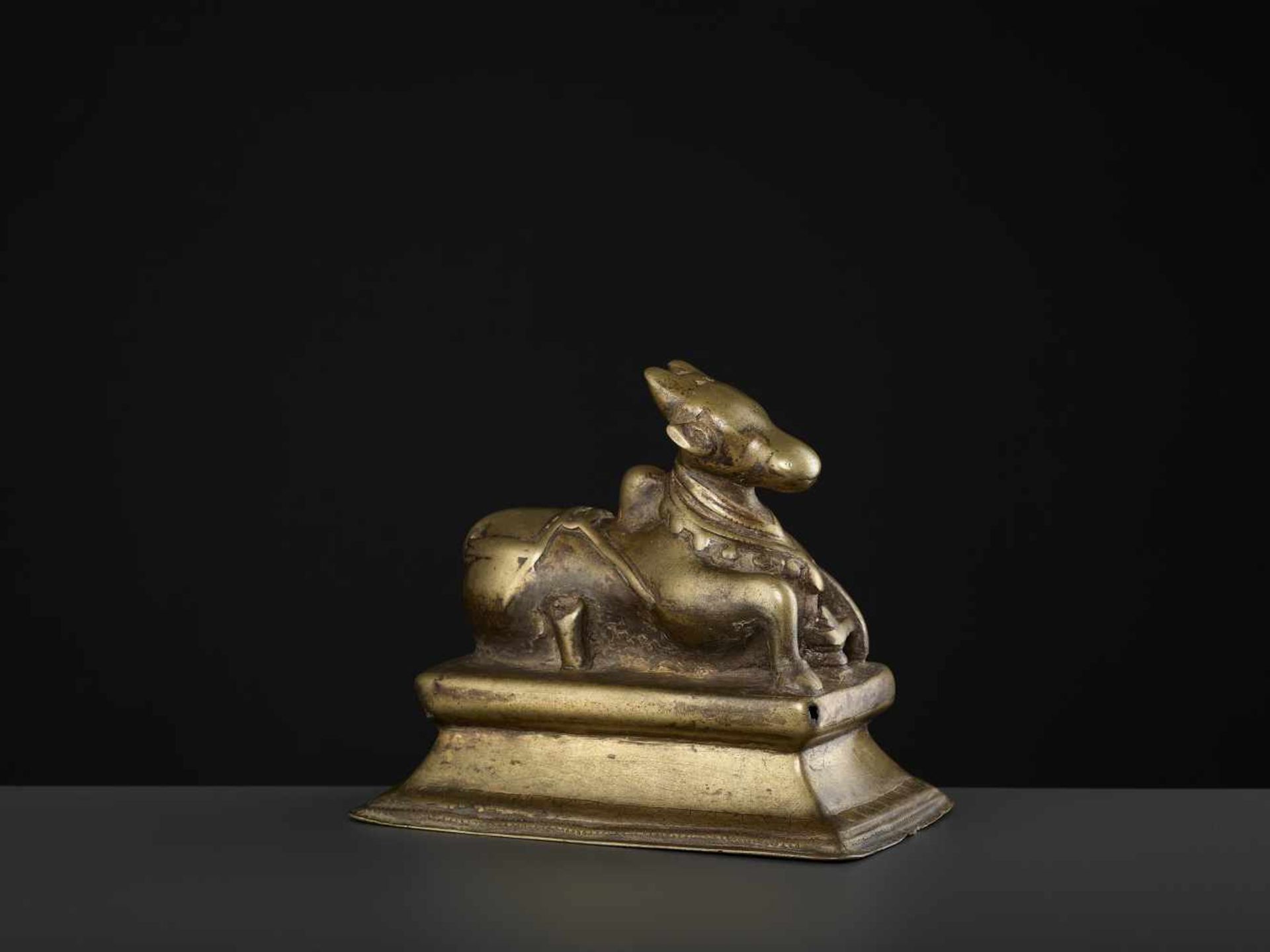 A BRASS NANDI 15TH CENTURYIndia, Himachal Pradesh. The divine cow reclining on a rectangular, - Image 5 of 7