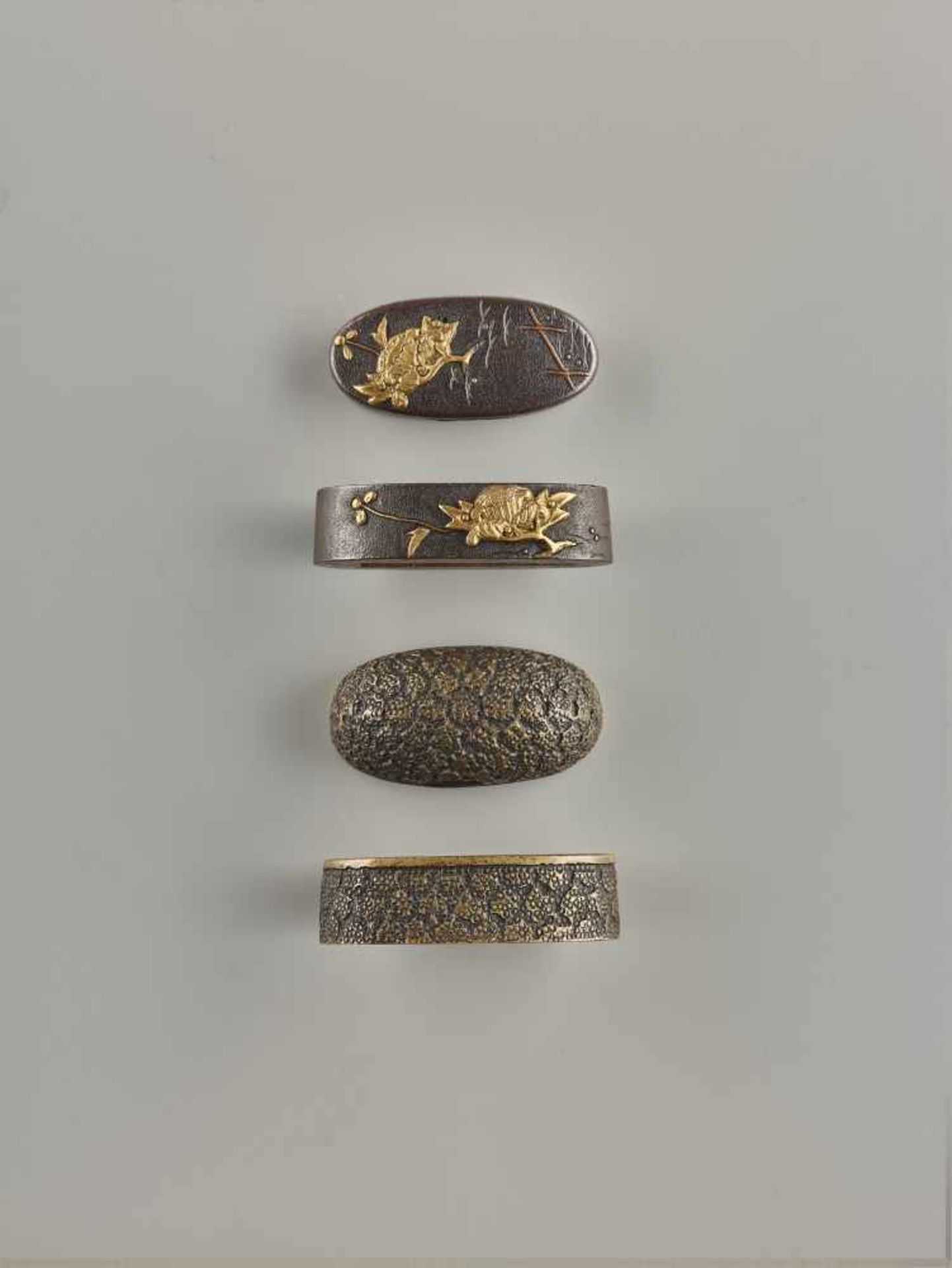 TWO FUCHI-KASHIRA Unsigned, shakudo with gold and bronzeJapan, Edo period (1615-1868)The first of